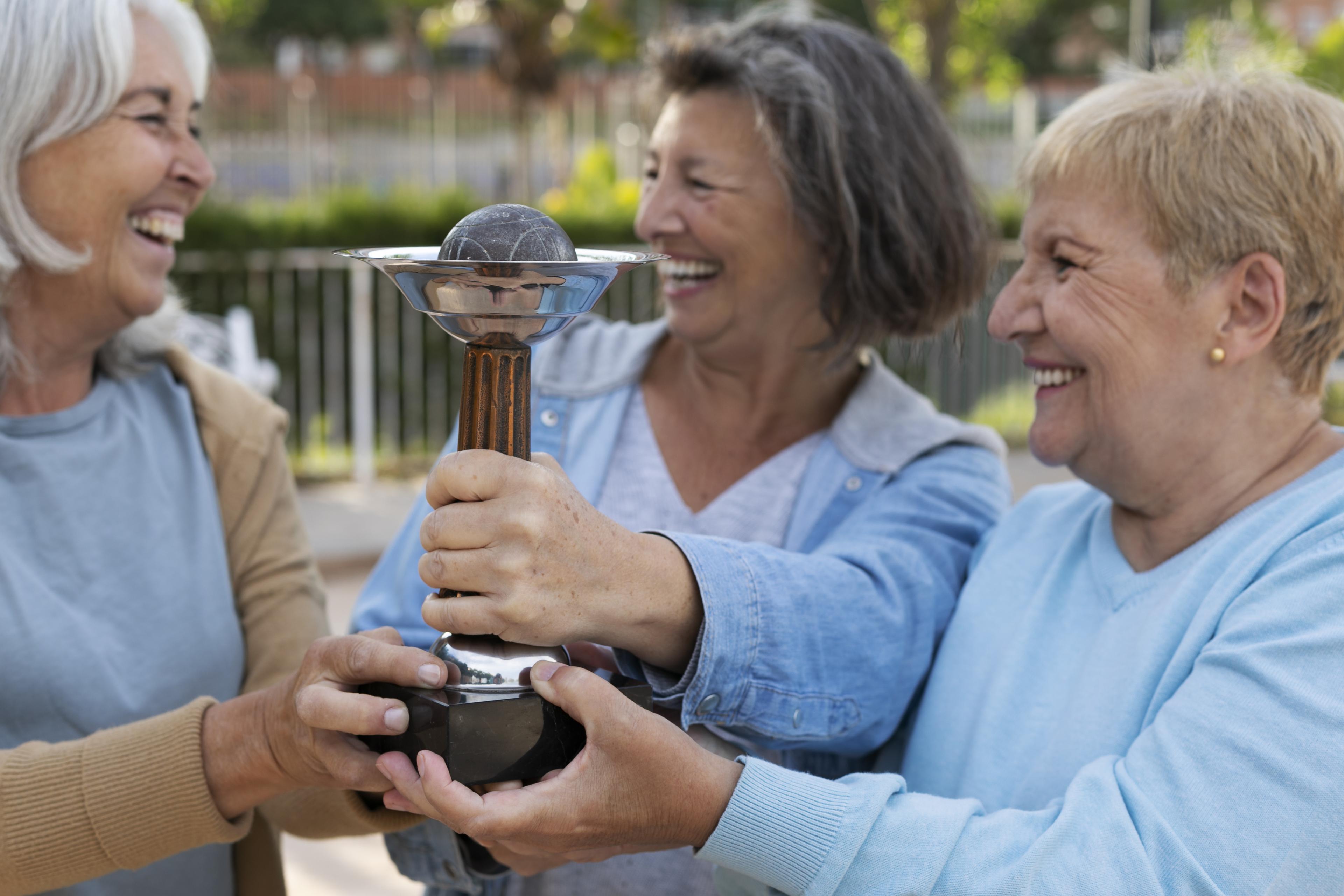 Three women holding a trophy.